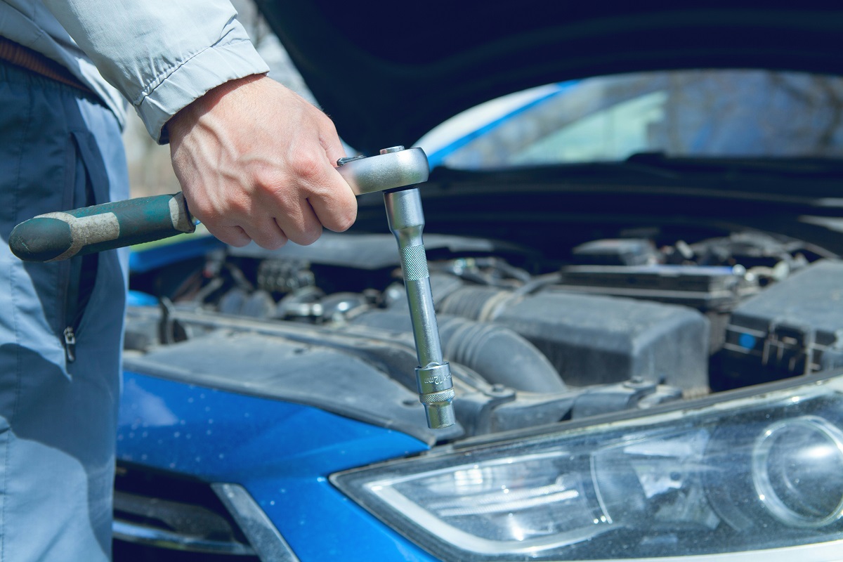 man fixing a car engine